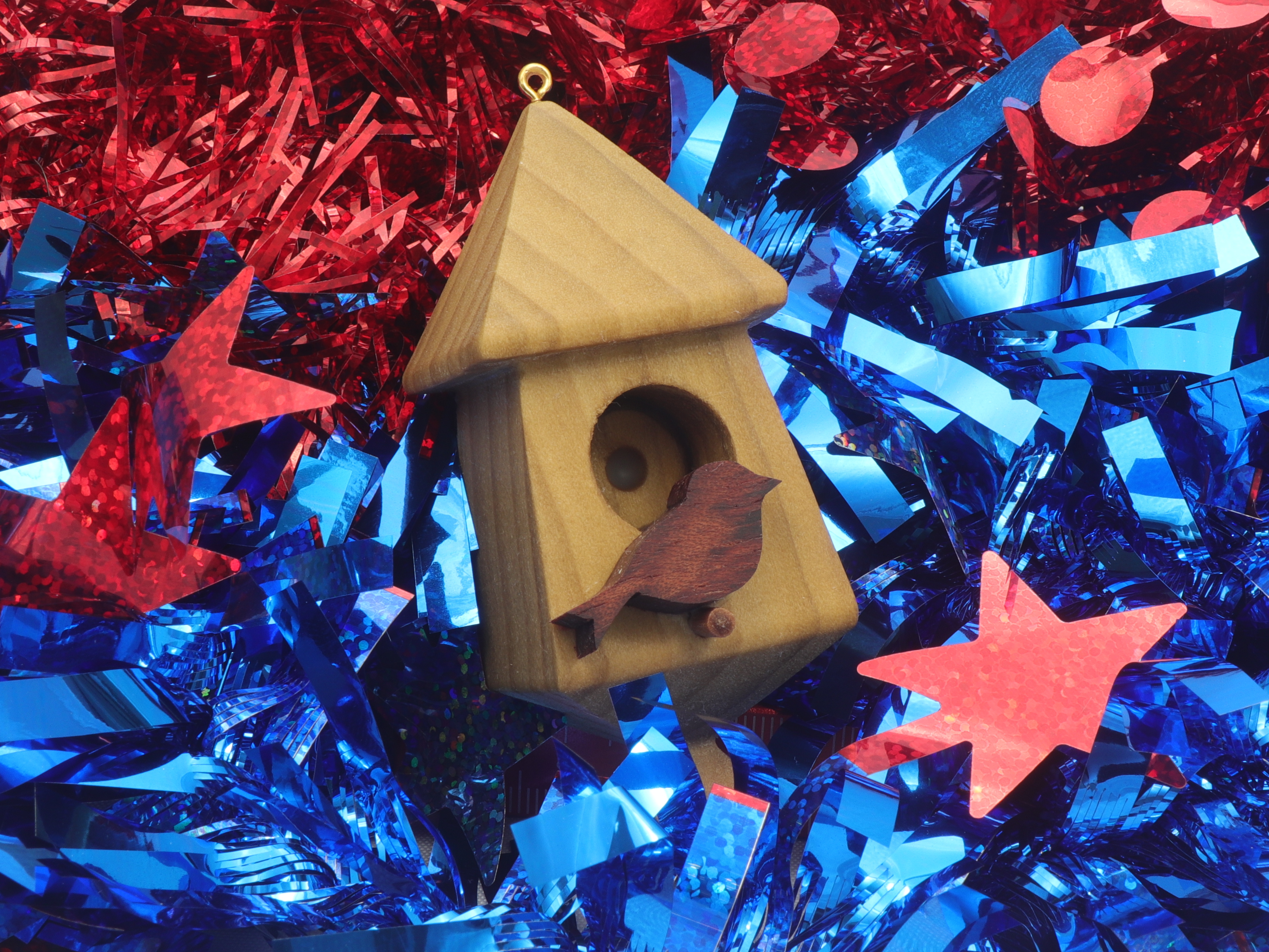 Handmade miniature birdhouse ornament crafted from select hardwoods, featuring a meticulous finish with a beeswax and oil blend—a collectible and charming decorative piece.