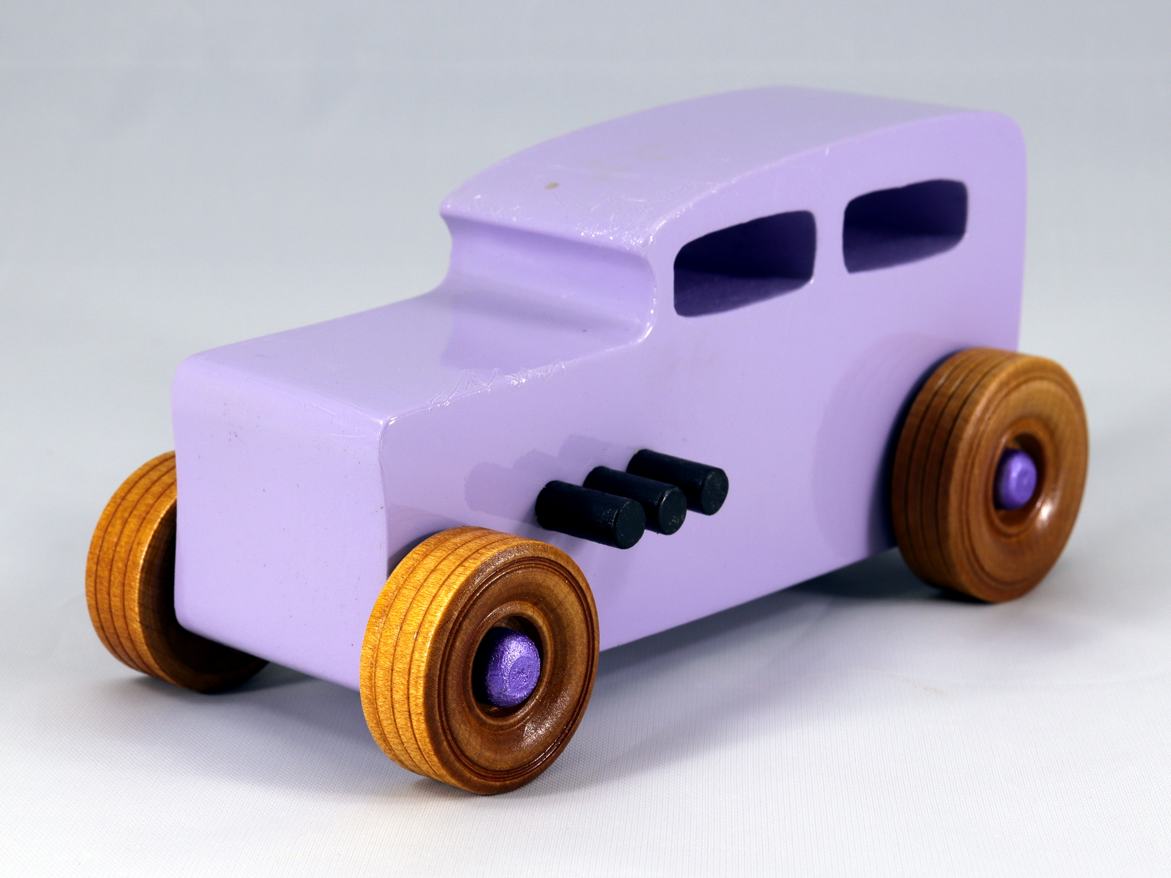 Handmade wooden toy car Hot Rod '32 Sedan painted with lavender, metallic purple, and black acrylic with non-marring amber shellac wheels.