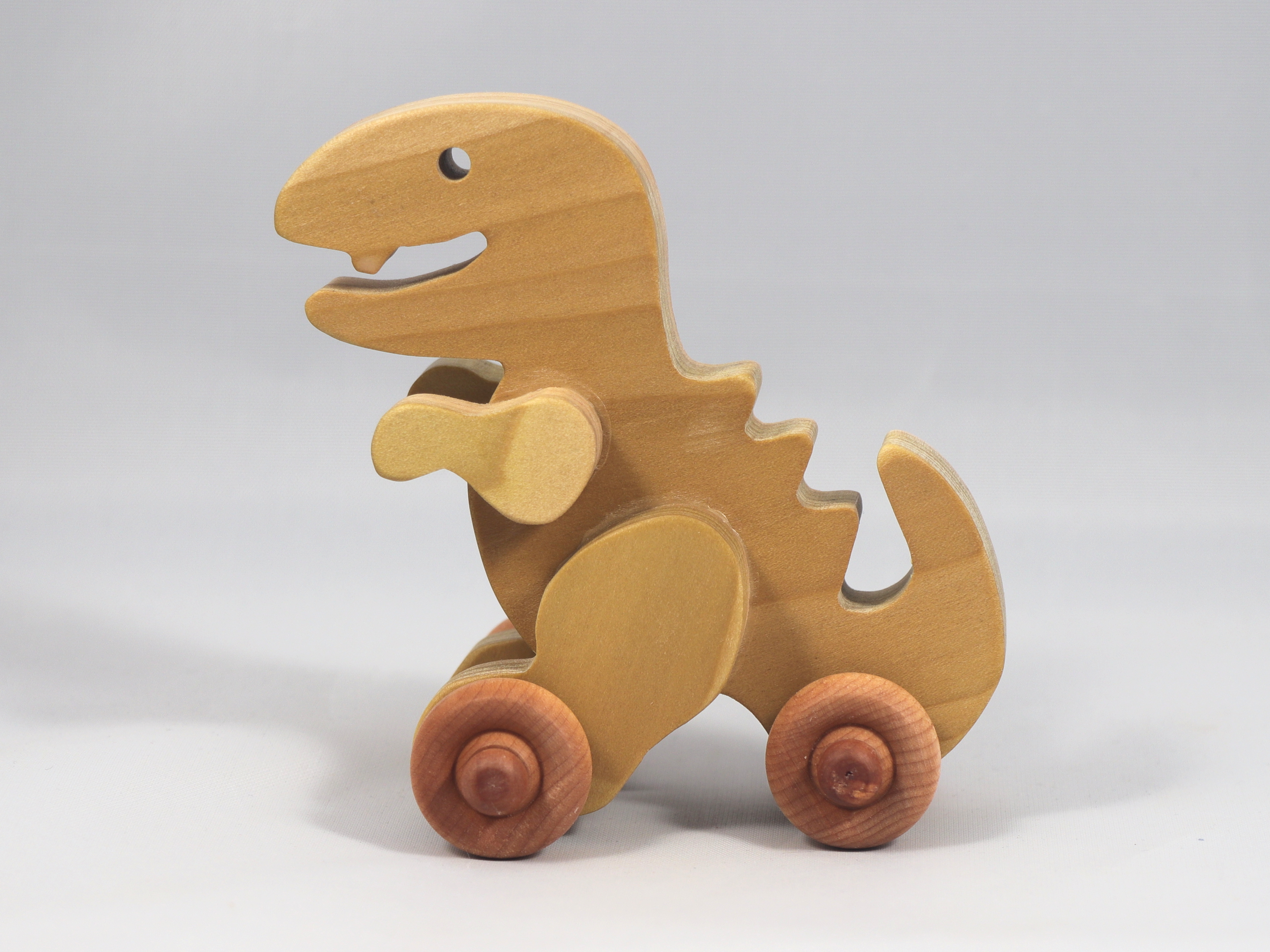 Handmade wooden push toy Tyrannosaurus Rex (T-Rex) dinosaur made from select grade hardwoods and finished with a non-toxic coating.